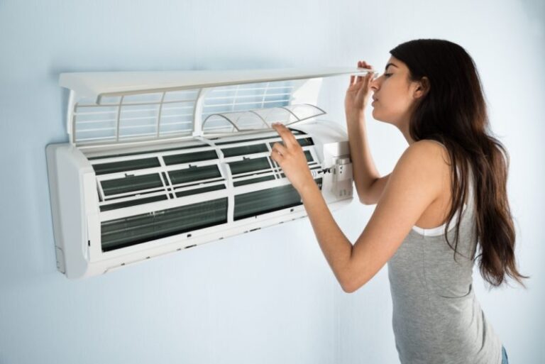 woman checking ductless air conditioner filter